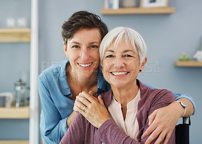 Buy stock photo Cropped portrait of an attractive young woman hugging her happy senior mother while at home