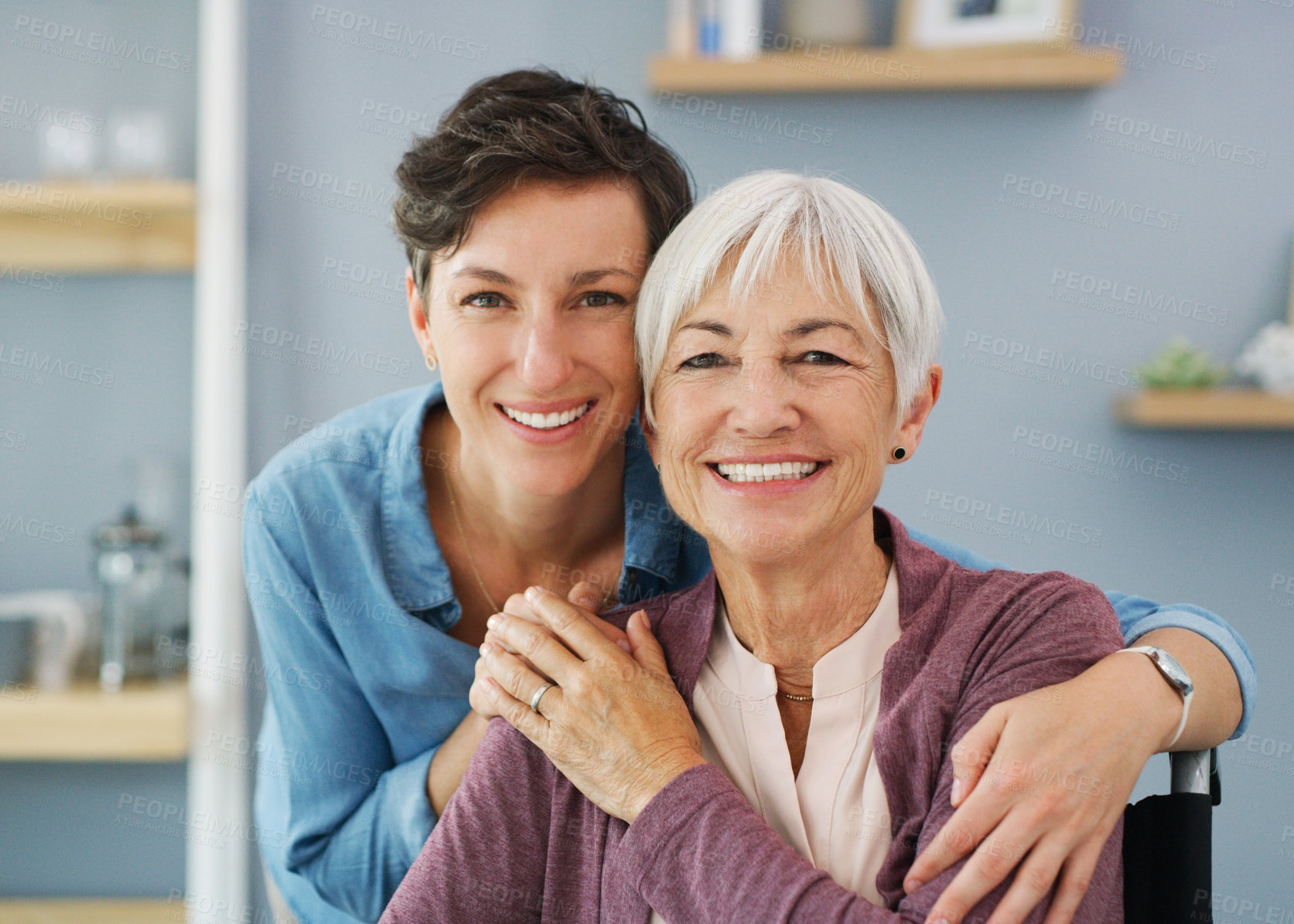Buy stock photo Cropped portrait of an attractive young woman hugging her happy senior mother while at home