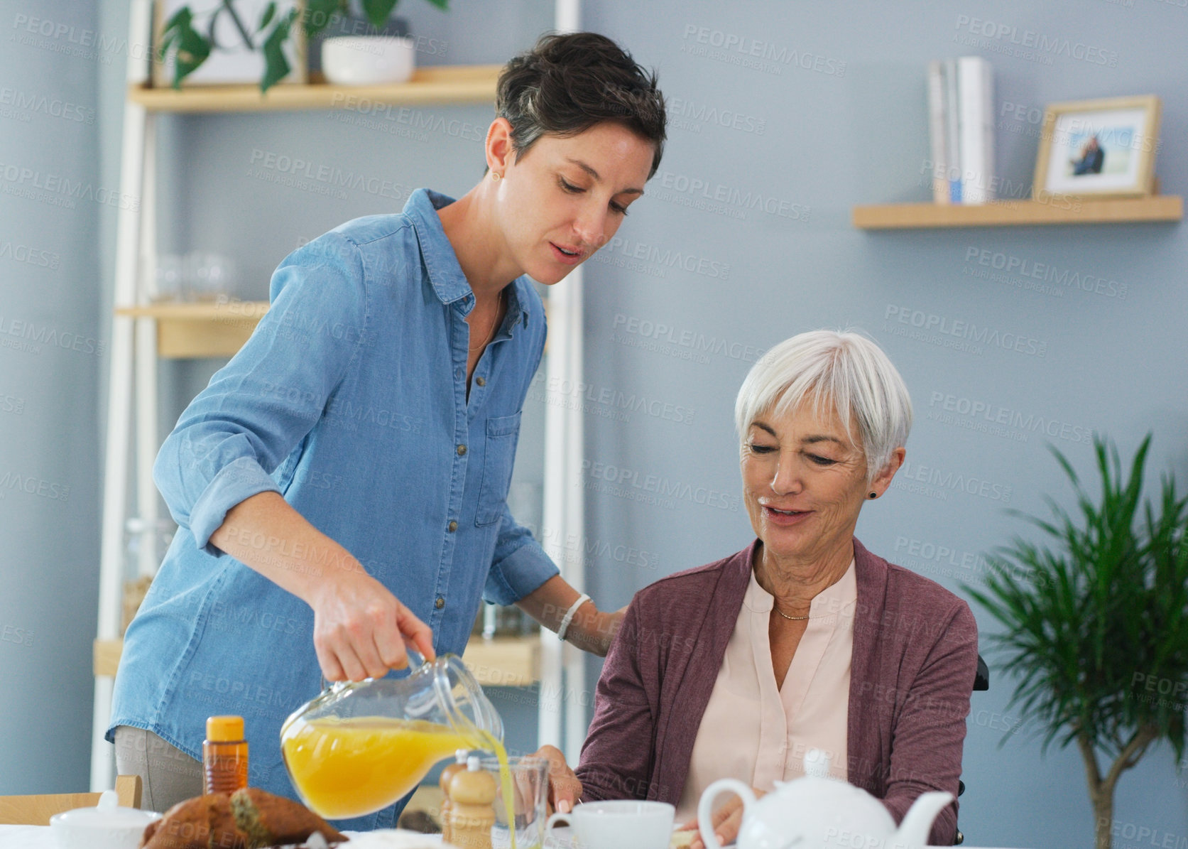Buy stock photo Cropped shot of a happy senior woman sitting and having breakfast with her attractive young daughter while at home