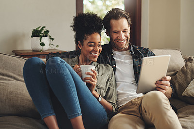 Buy stock photo Relax, home and interracial couple on a couch, tablet and happiness with social media and connection. Partners, man and woman on a sofa, technology and loving with a smile, romance and online reading