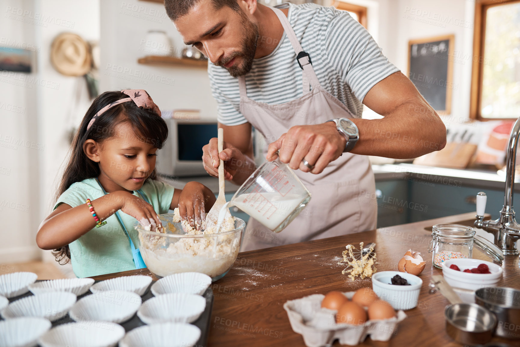 Buy stock photo Cropped shot of a young man baking at home with his young daughter