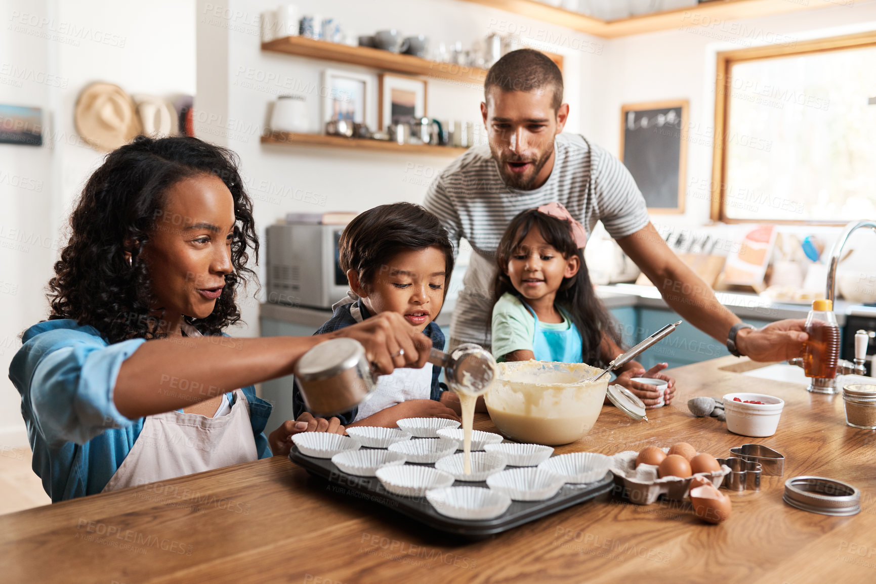 Buy stock photo Cropped shot of a young couple baking at home with their two children