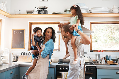 Buy stock photo Shot of a young family spending quality time together in the kitchen at home