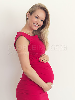 Buy stock photo Cropped portrait of an attractive young woman holding her belly while standing in her home
