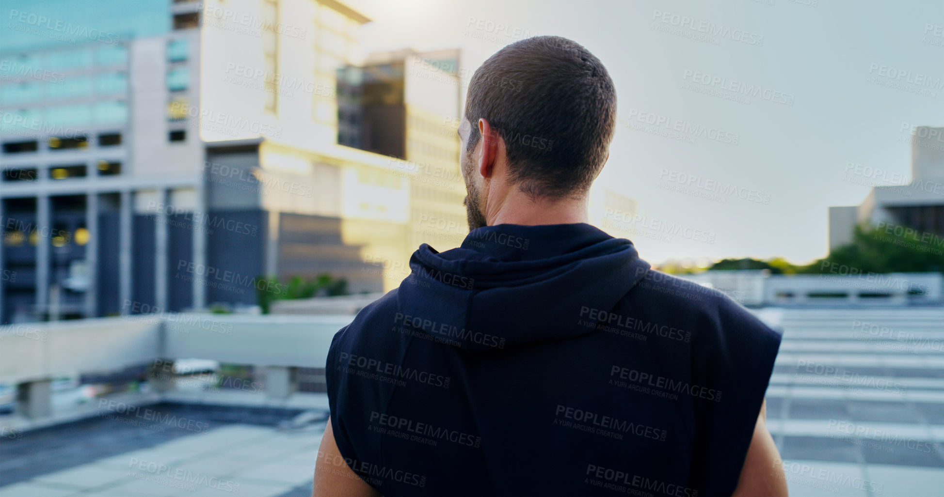 Buy stock photo Rearview shot of a young man going for a workout in the city