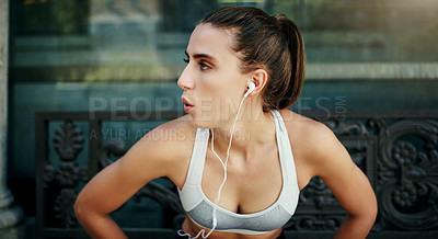 Buy stock photo Shot of a young woman taking a break from her workout in the city