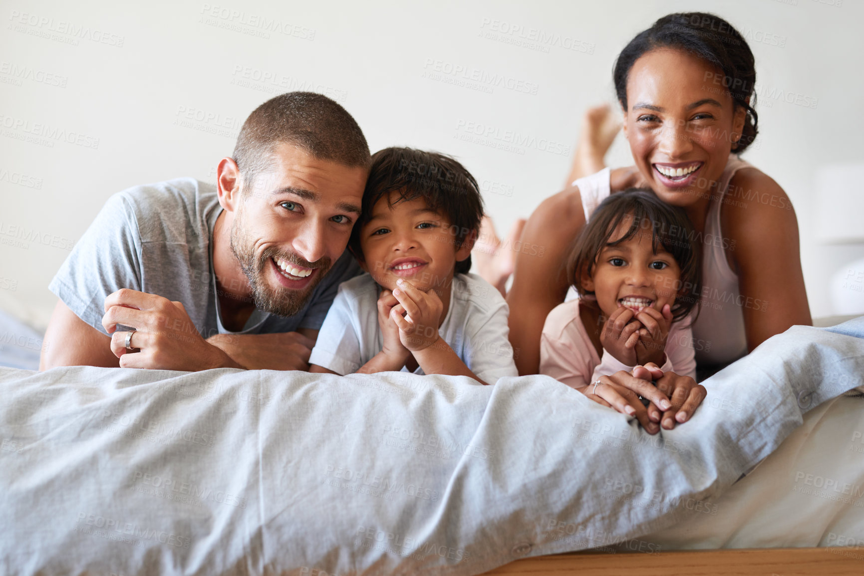 Buy stock photo Family, happy and portrait on bed for bonding, relax and support together with mother, father and kids. Parents, smile and children as people in home bedroom for love, relationship or care on weekend