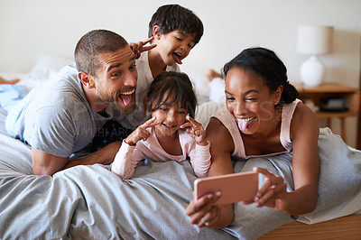 Buy stock photo Family, selfie and phone in bedroom for playful, relax and live streaming together with video or app. Parents, silly and children as people in home for photography, social media or memory with mobile