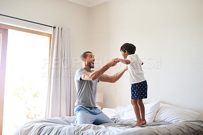 Buy stock photo Shot of a cheerful father and son playing together in the bedroom at home