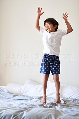 Buy stock photo Full length shot of an adorable little boy playing and jumping on a bed at home
