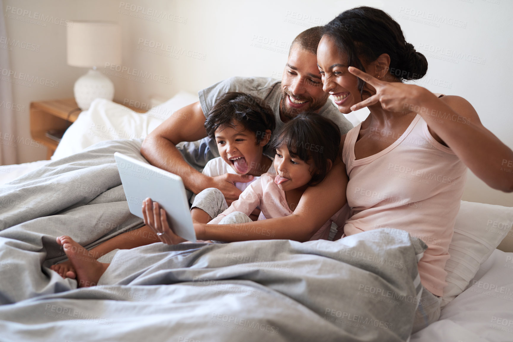 Buy stock photo Family, selfie and tablet on bed for bonding, relax and live streaming together with video and app. Parents, smile and children as people in home bedroom for film, social media and memory on weekend