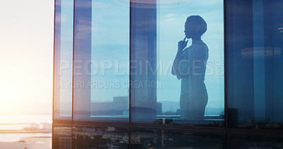 Buy stock photo Shot of a businesswoman looking thoughtful while looking out a window