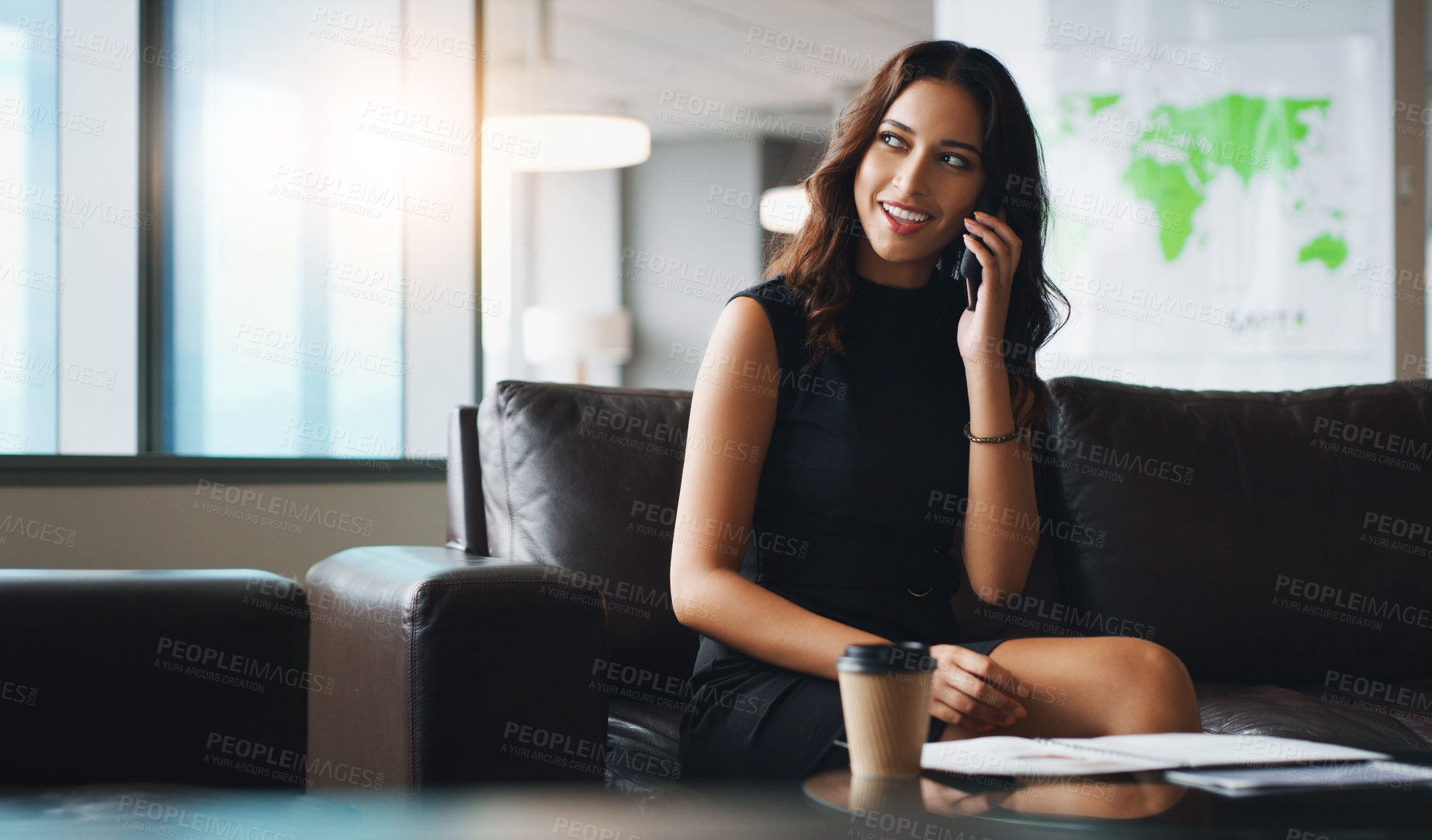 Buy stock photo Shot of a businesswoman talking on her cellphone while sitting in a modern office