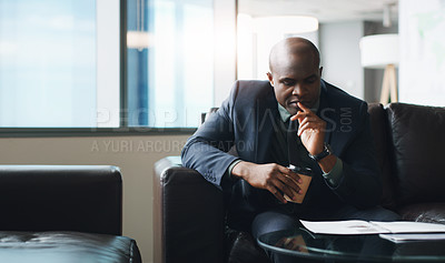 Buy stock photo Shot of a businessman looking thoughtful while sitting in a modern office