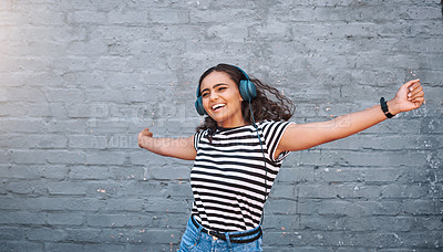 Buy stock photo Girl, headphones and music dancing with brick wall or listening entertainment, celebration or radio. Female person, happiness and playlist streaming in urban city with track, subscription or audio