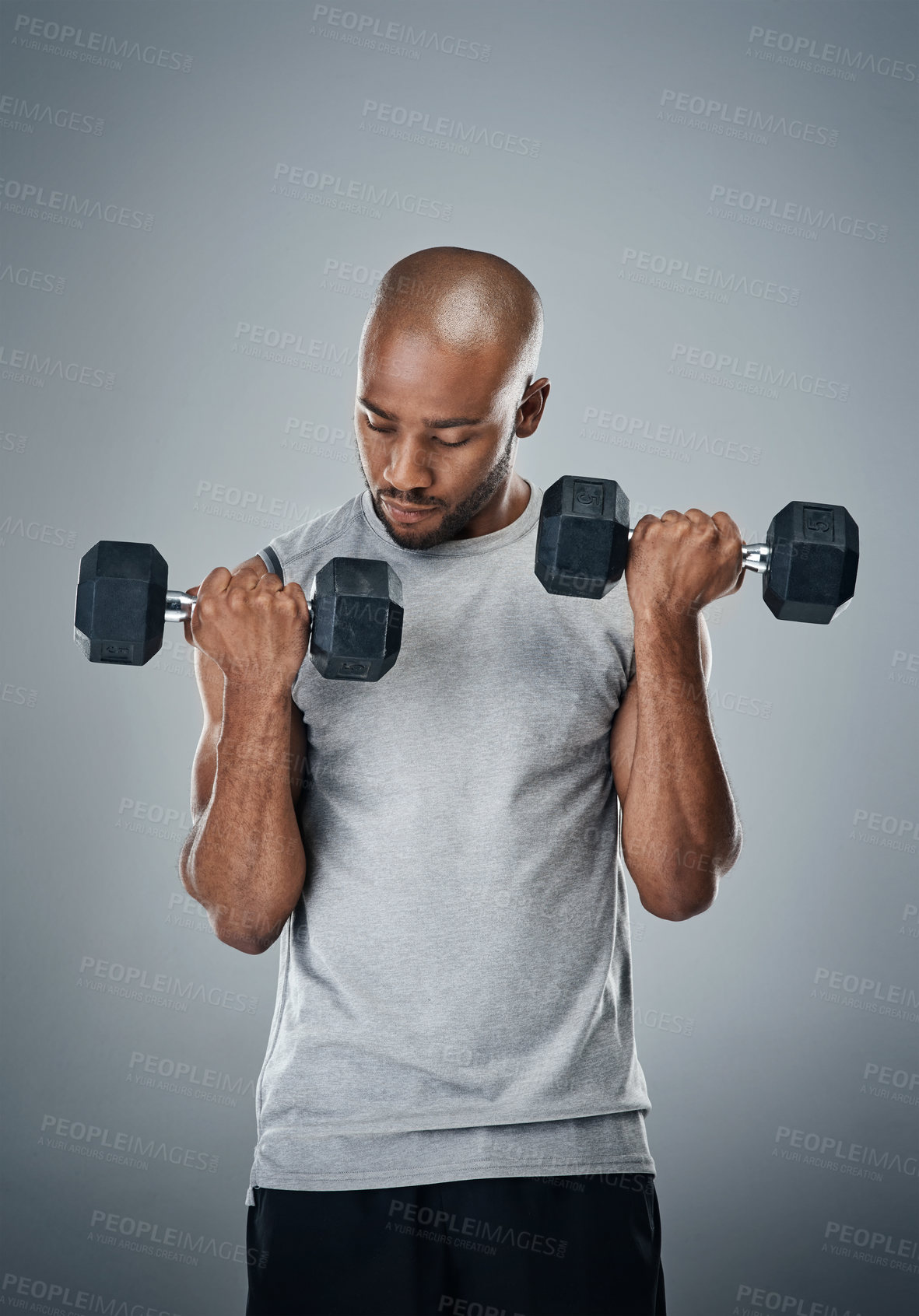Buy stock photo Black man, dumbbells and muscle training in studio, sports performance and lift on gray background. Male person, strong bicep challenge and weightlifting for power, bodybuilder and fitness workout