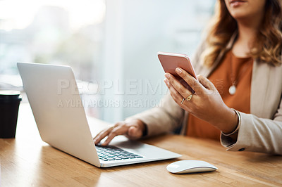 Buy stock photo Shot of an unrecognizable businesswoman using a cellphone and laptop in her office