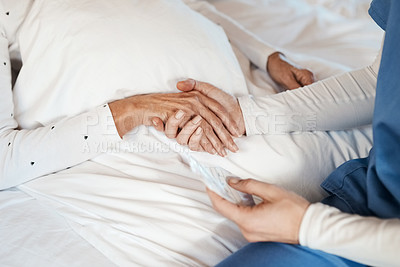 Buy stock photo Cropped shot of a nurse holding hands with a senior woman