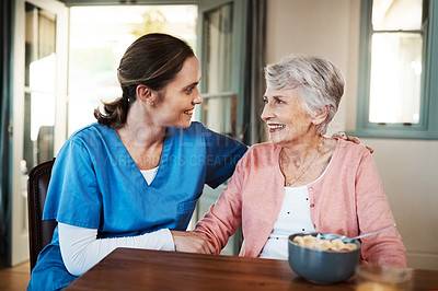 Buy stock photo Shot of a young nurse sitting with a senior woman at breakfast time in a nursing home