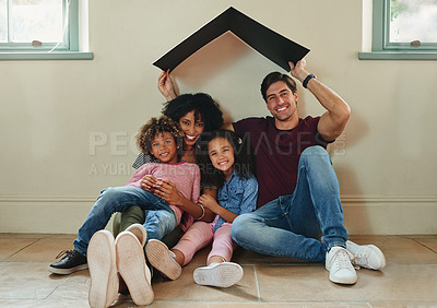 Buy stock photo Full length portrait of a beautiful young family of four sitting on the floor together at home