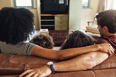 Buy stock photo Rearview shot of a beautiful young family of four watching tv together at home