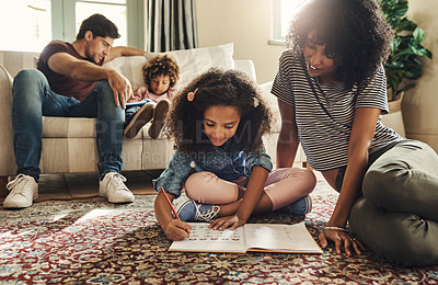 Buy stock photo Shot of a mother and father helping their two young children with their homework at home