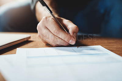 Buy stock photo Shot of an unrecognizable businessman signing paperwork in his office at home