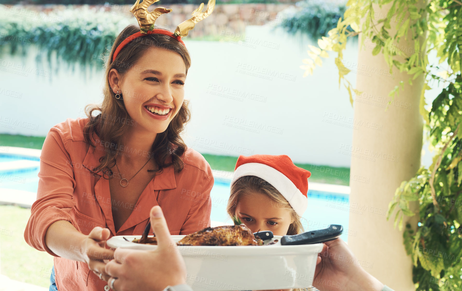 Buy stock photo Shot of a beautiful young mother handing over a bowl of food at a Christmas lunch party