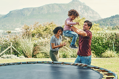 Buy stock photo Parents, trampoline and boy jump in outdoor, playing and father helping in backyard of home. Son, family and kid energy for fun activity in childhood, garden and bounce movement for bonding together