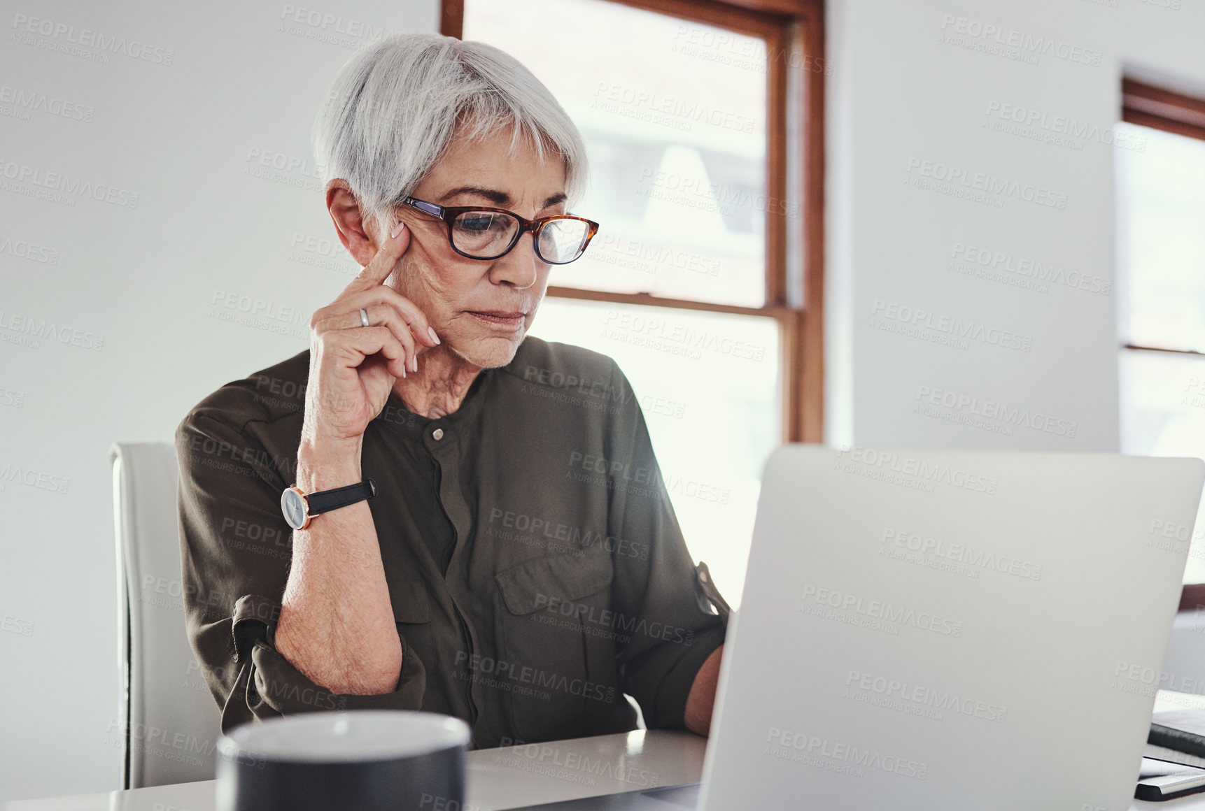 Buy stock photo Cropped shot of an attractive mature businesswoman working on her laptop in the office