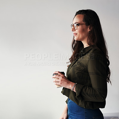Buy stock photo Cropped shot of an attractive young businesswoman holding a cup of coffee while standing alone in the office