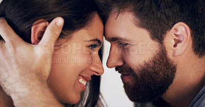Buy stock photo Shot of an affectionate young couple sharing a romantic moment in the bedroom at home