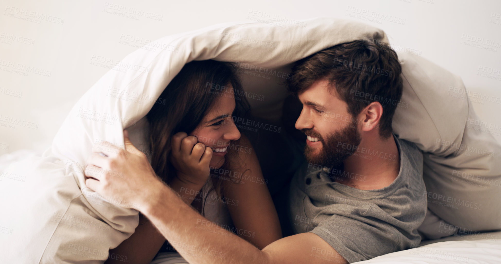 Buy stock photo Happy, bed and couple with blanket at morning with hug at home with love, marriage and cuddling together. Smile, bonding and bedding fort in bedroom in a house with care and romance with cotton duvet