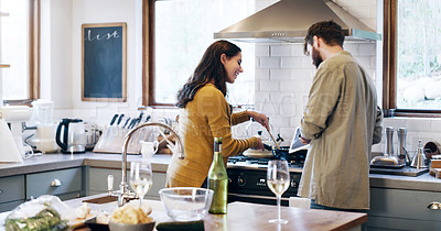 Buy stock photo Shot of a young couple using a digital tablet while preparing a meal at home
