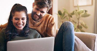 Buy stock photo Shot of a young couple using a laptop while relaxing on the sofa at home