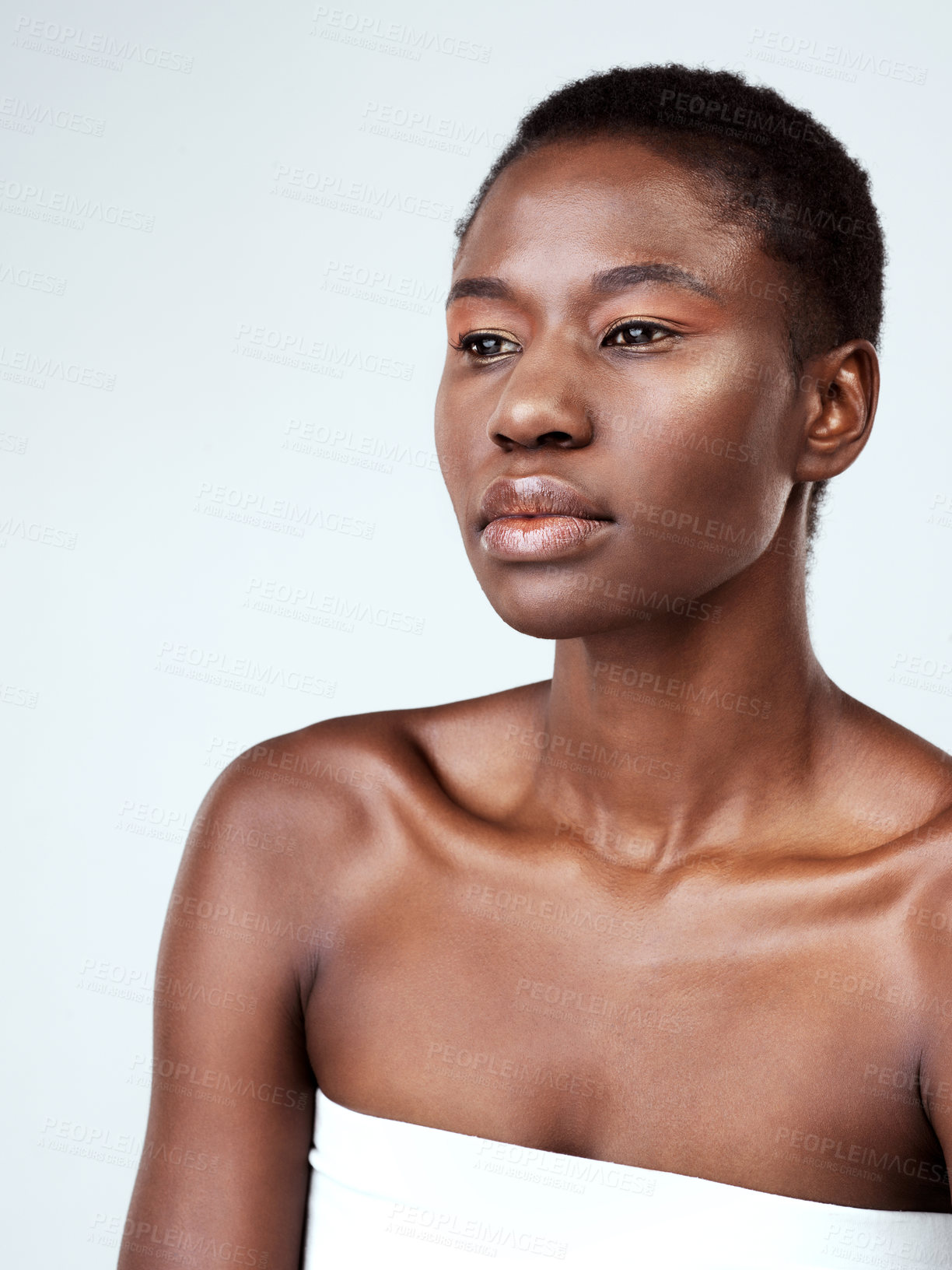 Buy stock photo Studio shot of a beautiful young woman looking thoughtful against a grey background