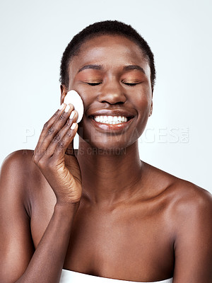 Buy stock photo Studio shot of a beautiful young woman wiping her face with cotton against a grey background