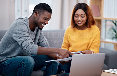Buy stock photo Shot of a couple going through some paperwork while sitting with a laptop