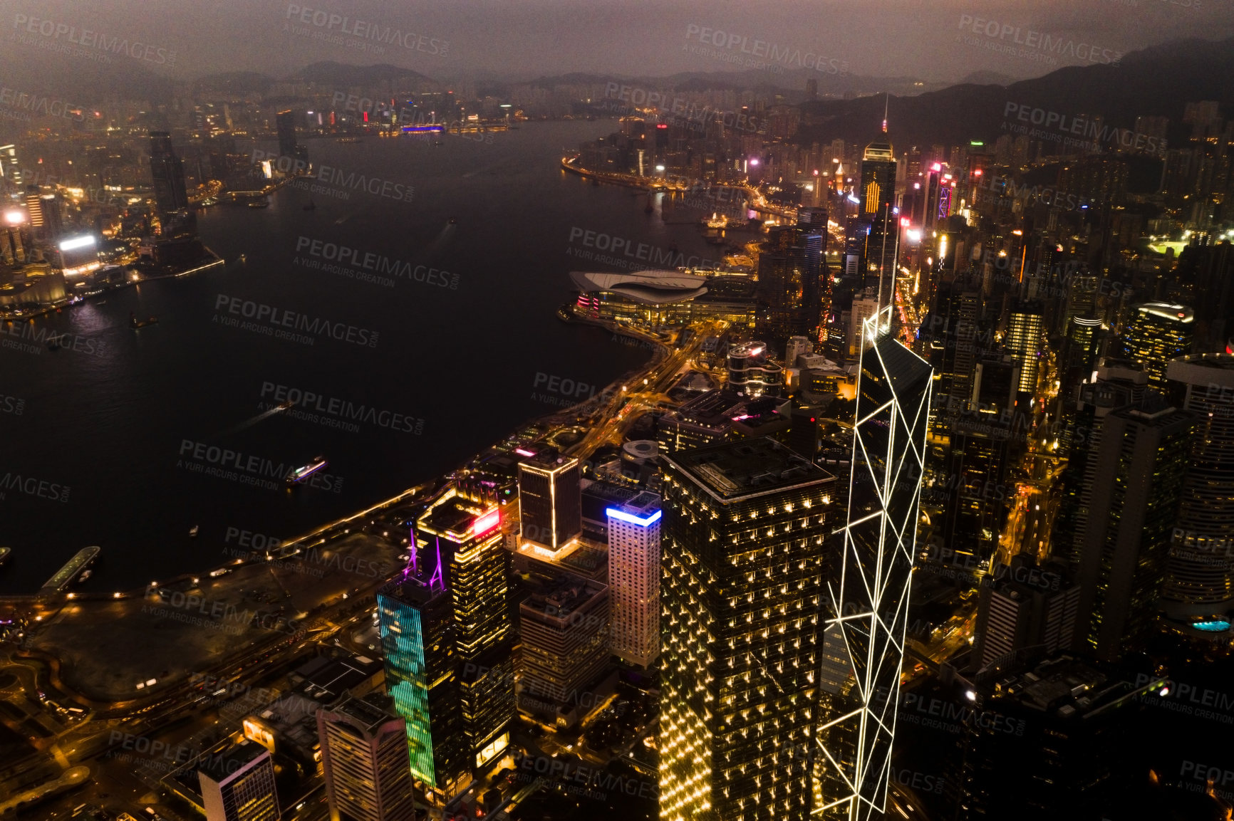 Buy stock photo Aerial, skyscrapers and night city of office buildings with lake, lights and riverside in the outdoors. Drone view of CBD, architecture or cityscape and late infrastructure lighting of a urban town