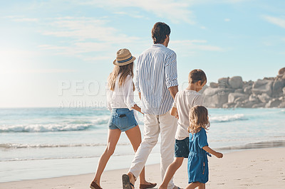 Buy stock photo Rearview shot of an unrecognizable couple holding hands with their two children and walking along the beach