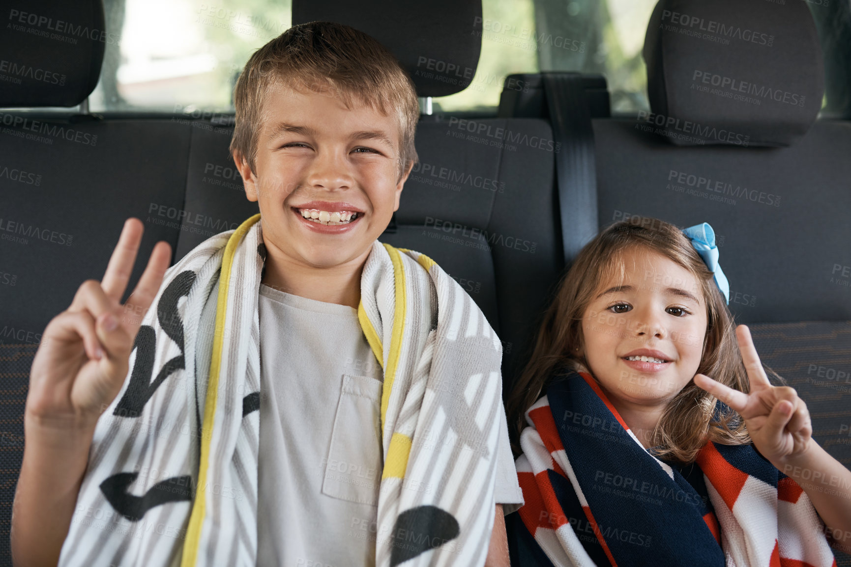 Buy stock photo Cropped portrait of two young siblings sitting in the car and making peace sign gestures before going on a roadtrip