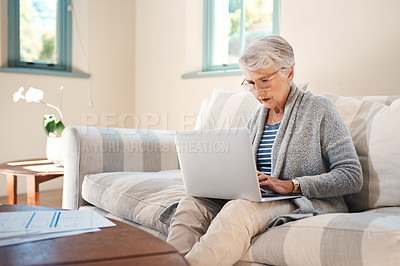 Buy stock photo Shot of a senior woman going through paperwork at home