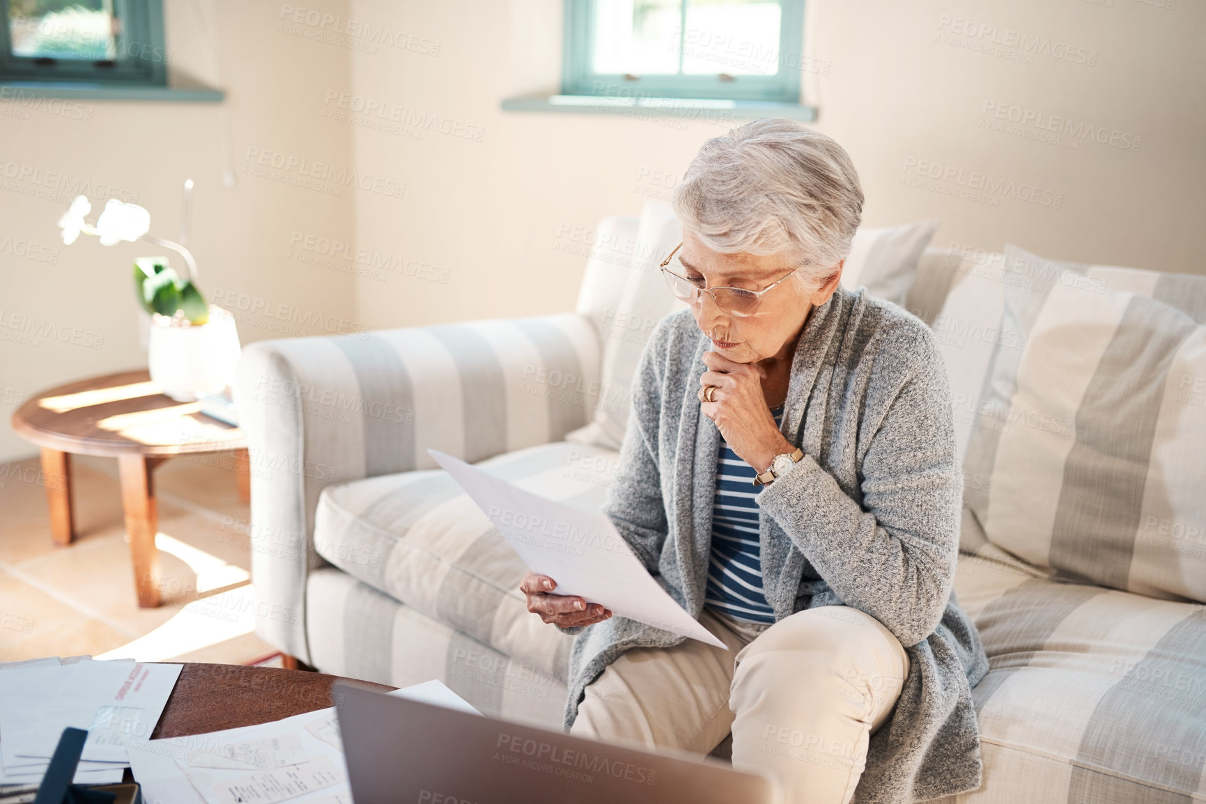 Buy stock photo Shot of a senior woman going through paperwork at home