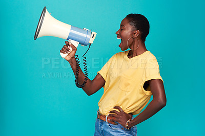 Buy stock photo Studio shot of a young woman using a megaphone against a turquoise background