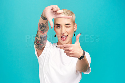 Buy stock photo Studio shot of a confident young woman making a finger frame of her face against a turquoise background