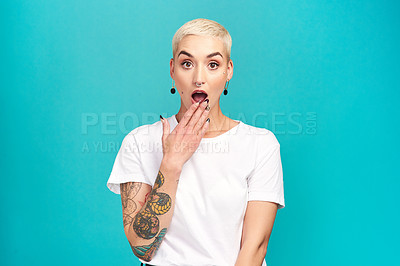 Buy stock photo Studio shot of a young woman looking shocked against a turquoise background
