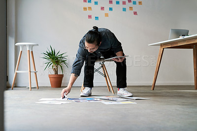 Buy stock photo Full length shot of a handsome creative young businessman sitting on a chair and using his digital tablet at work