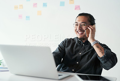 Buy stock photo Shot of a handsome young businessman making a phone call while working in his office
