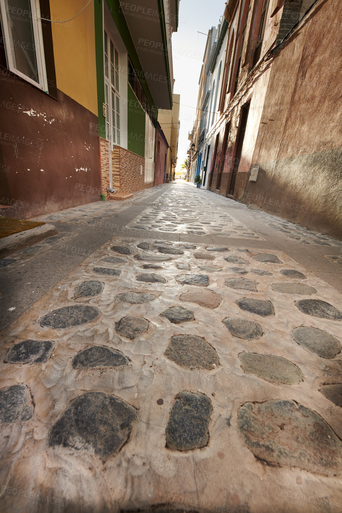 Buy stock photo Stone alleyway road with scenic view of dark residential buildings, old historic houses with traditional infrastructure. Tourism abroad, overseas travel destination in Santa Cruz, La Palma, Spain