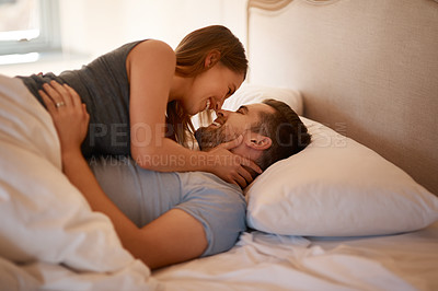 Buy stock photo Love, care and happy couple in bed with romance, desire or intimacy, connection or bonding at home. Eye contact, foreplay and passion, attraction or trust in bedroom for anniversary or honeymoon